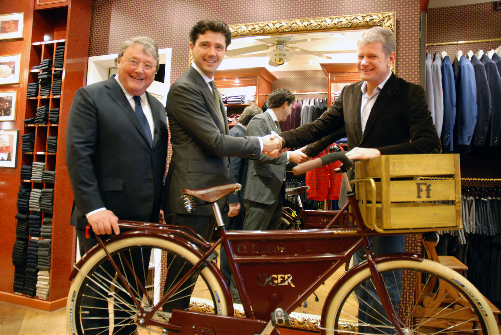 Bij Oger kunnen klanten voortaan niet alleen terecht voor een maatpak, maar ook voor een maatfiets van De Fietsfabriek. Links op de foto Oger Lusink, uiterst rechts Wessel Berkman. 