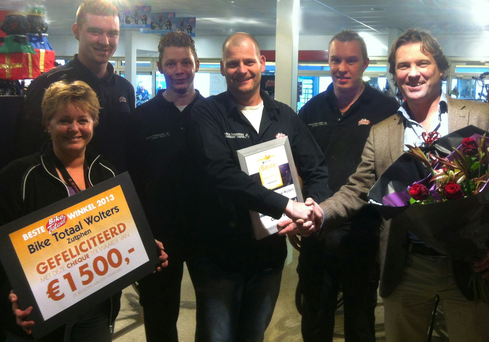 Eigenaar Chris Wolters en medewerkers krijgen de oorkonde en een cheque ter waarde van € 1.500,- voor een teamuitje uitgereikt door Maarten de Vos, directeur Bike Totaal Nederland.