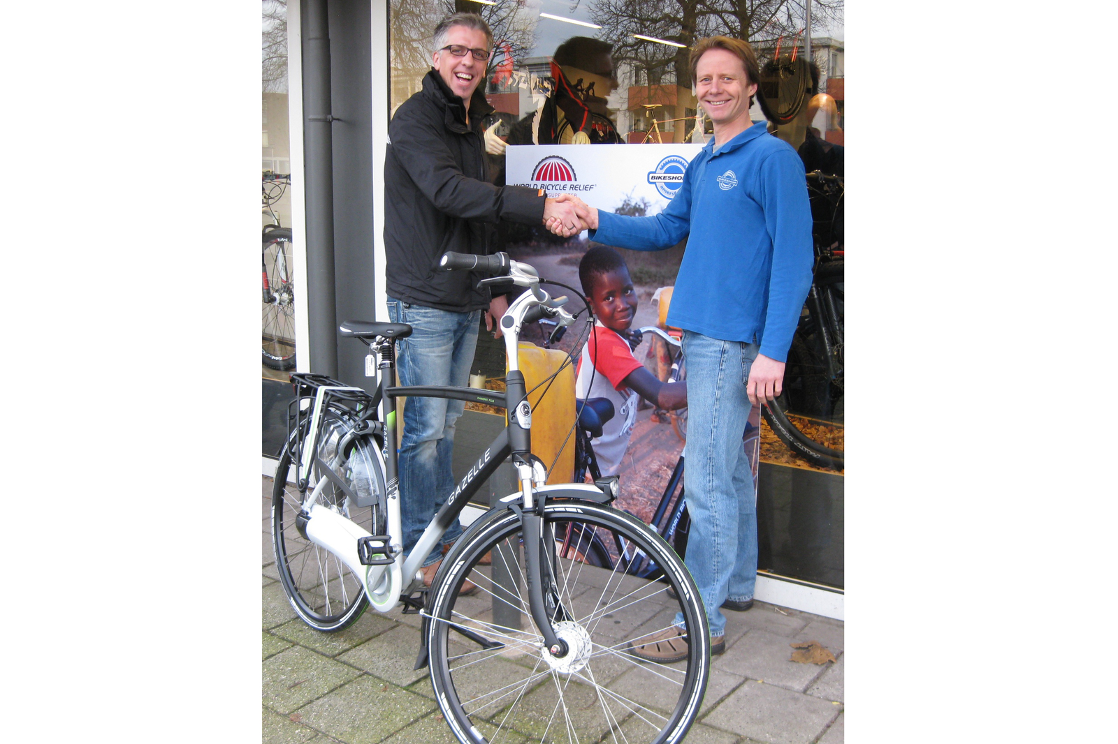 Eugen Uppelschoten van Bikeshop Amersfoort overhandigt de Gazelle-fiets in het kader van de World Bicycle Relief-actie aan Martijn.