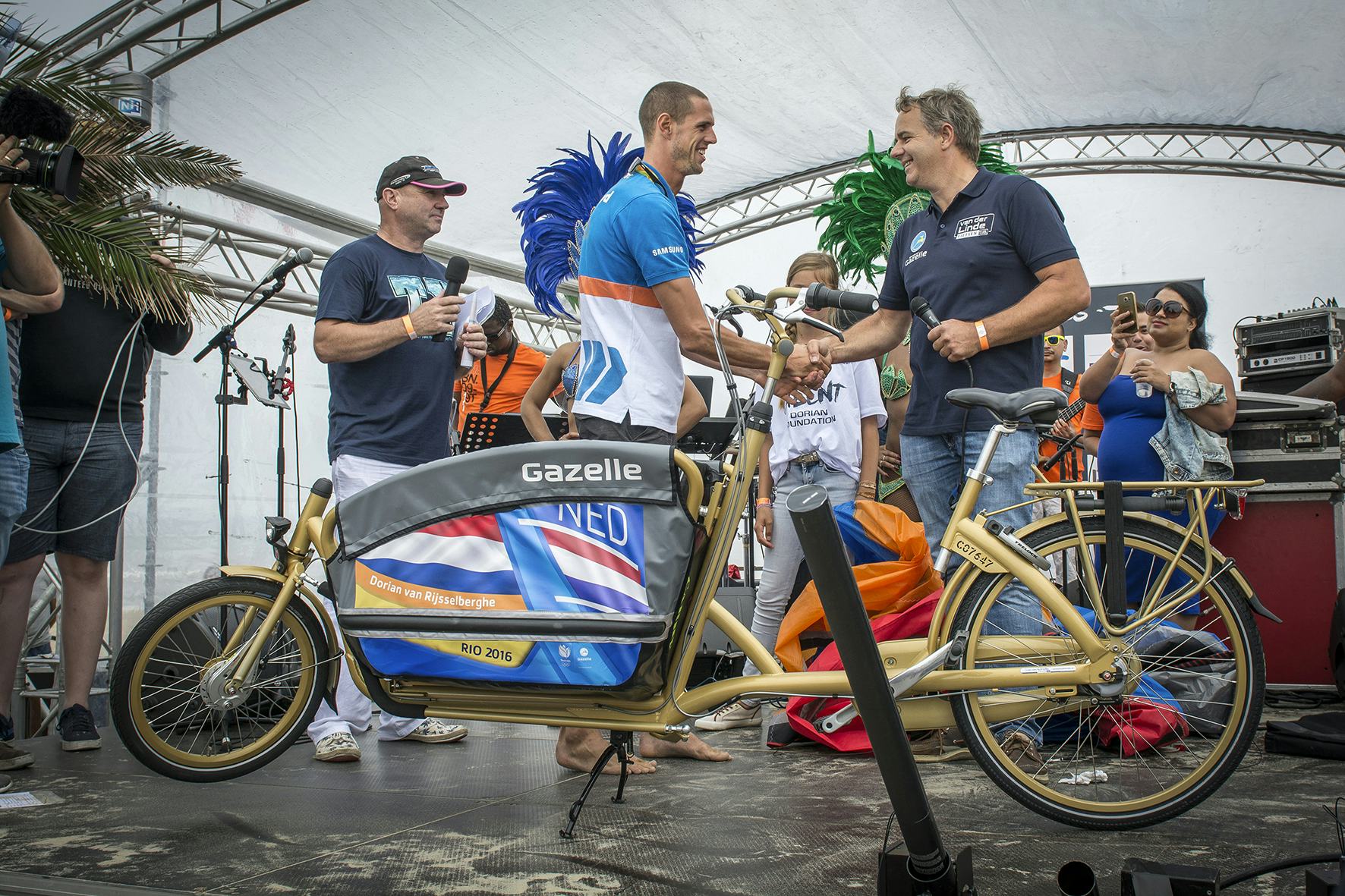 Erwin van der Linde van de lokale tweewielerzaak overhandigt de bakfiets aan Dorian van Rijsselberghe. Foto Gazelle