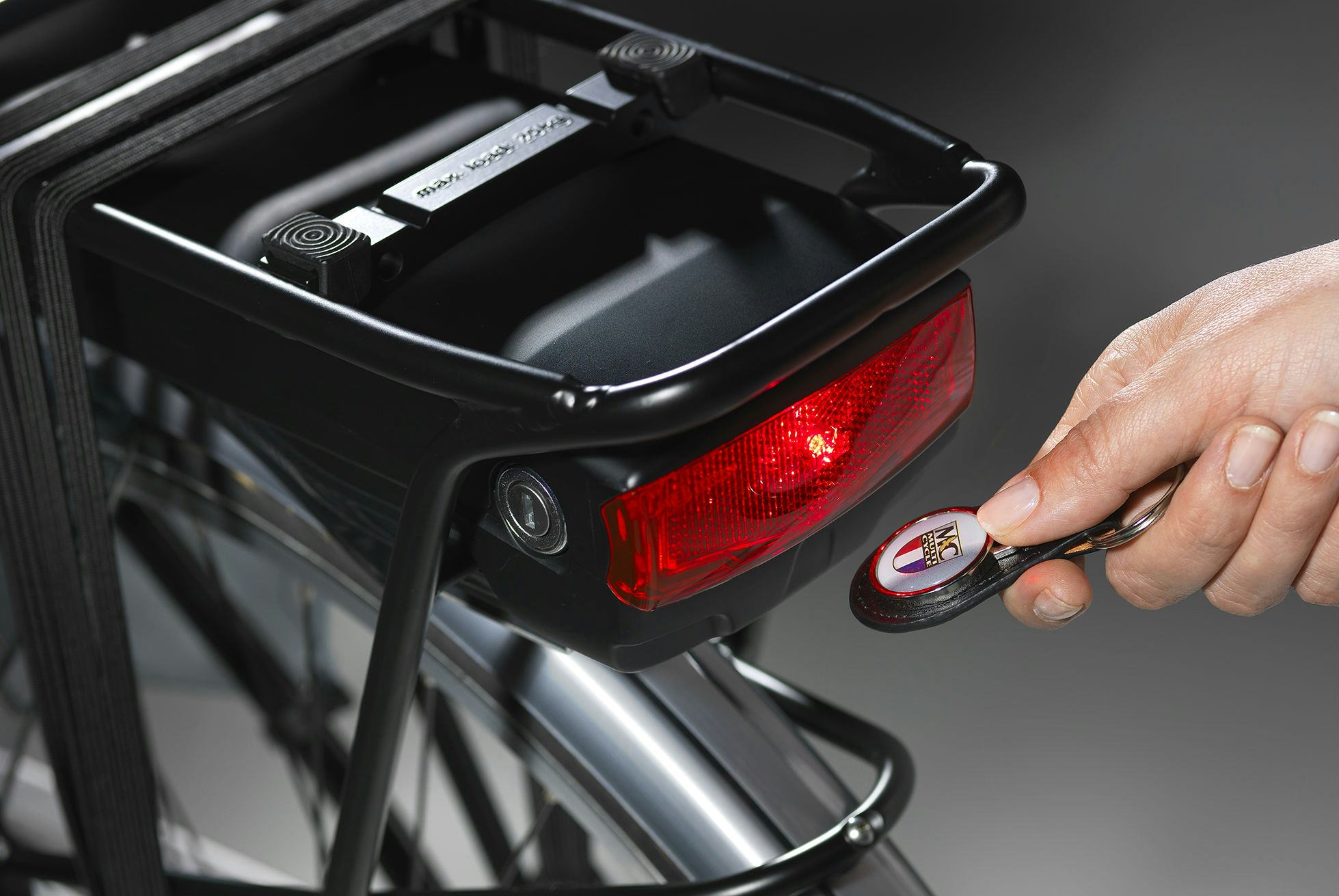 Multicycle magneetsleutelhanger; het elektrische systeem kan eenvoudig en makkelijk in- en uitgeschakeld worden door de MC-magneetsleutelhanger even voor de sensor onder het achterlicht te houden. Foto Multicycle