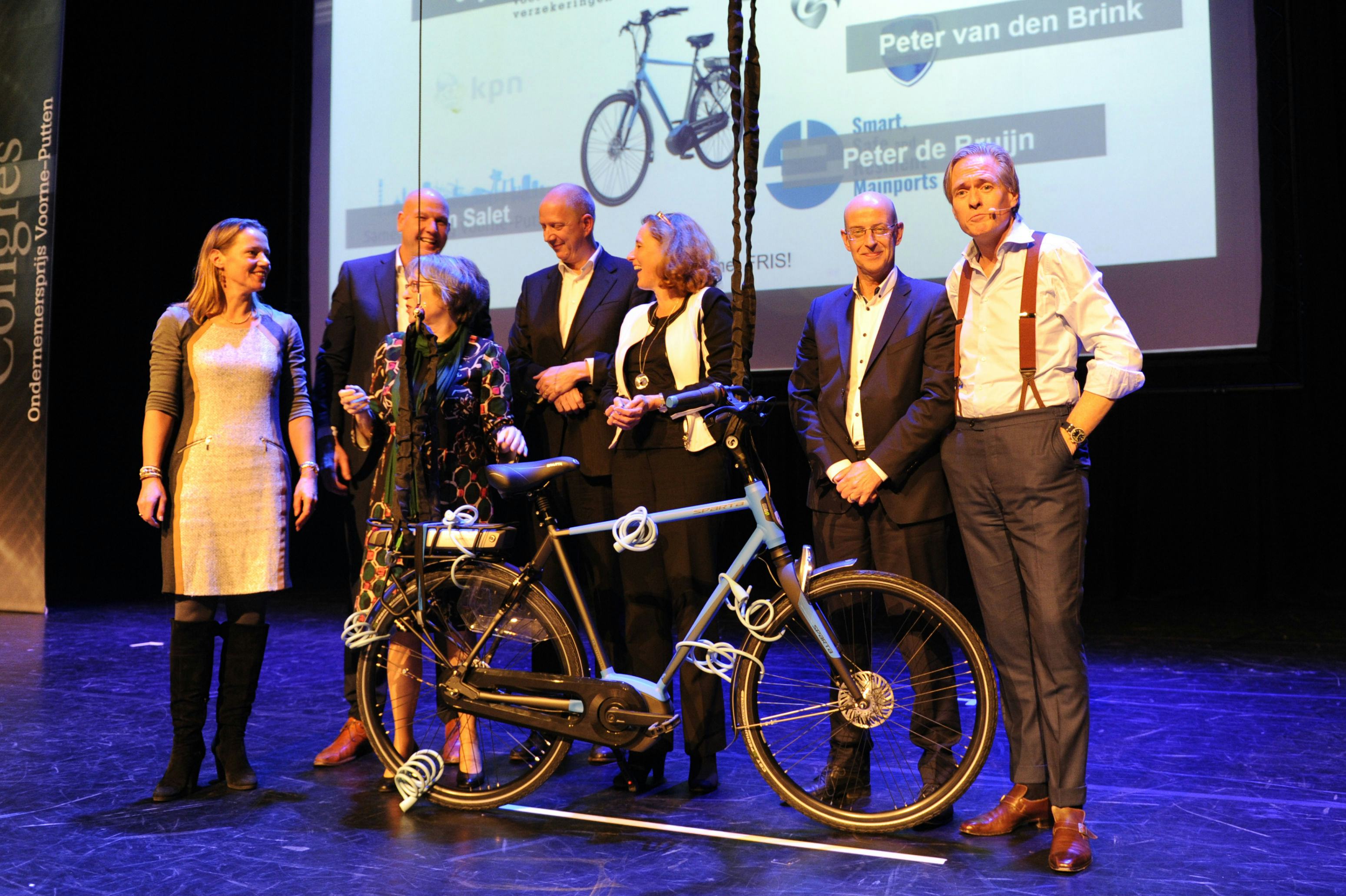 Tijdens het Congres van de Economic Board Voorne-Putten op 12 december jl. is de overeenkomst tussen de partners letterlijk gesloten door gezamenlijk de Sparta e-bike op slot te zetten. V.l.n.r. Joyce Burkens (directeur Europeesche verzekeringen), Mark Kuper (commercieel directeur Accell Nederland), Mirjam Salet (burgemeester Nissewaard), Peter de Bruijn (bestuurder FRIS ai), Adri Bom (gedeputeerde Provincie Zuid-Holland), Peter van der Brink (directeur BHD Nederland), Jort Kelder (journalist). Foto © Tessa Huisman