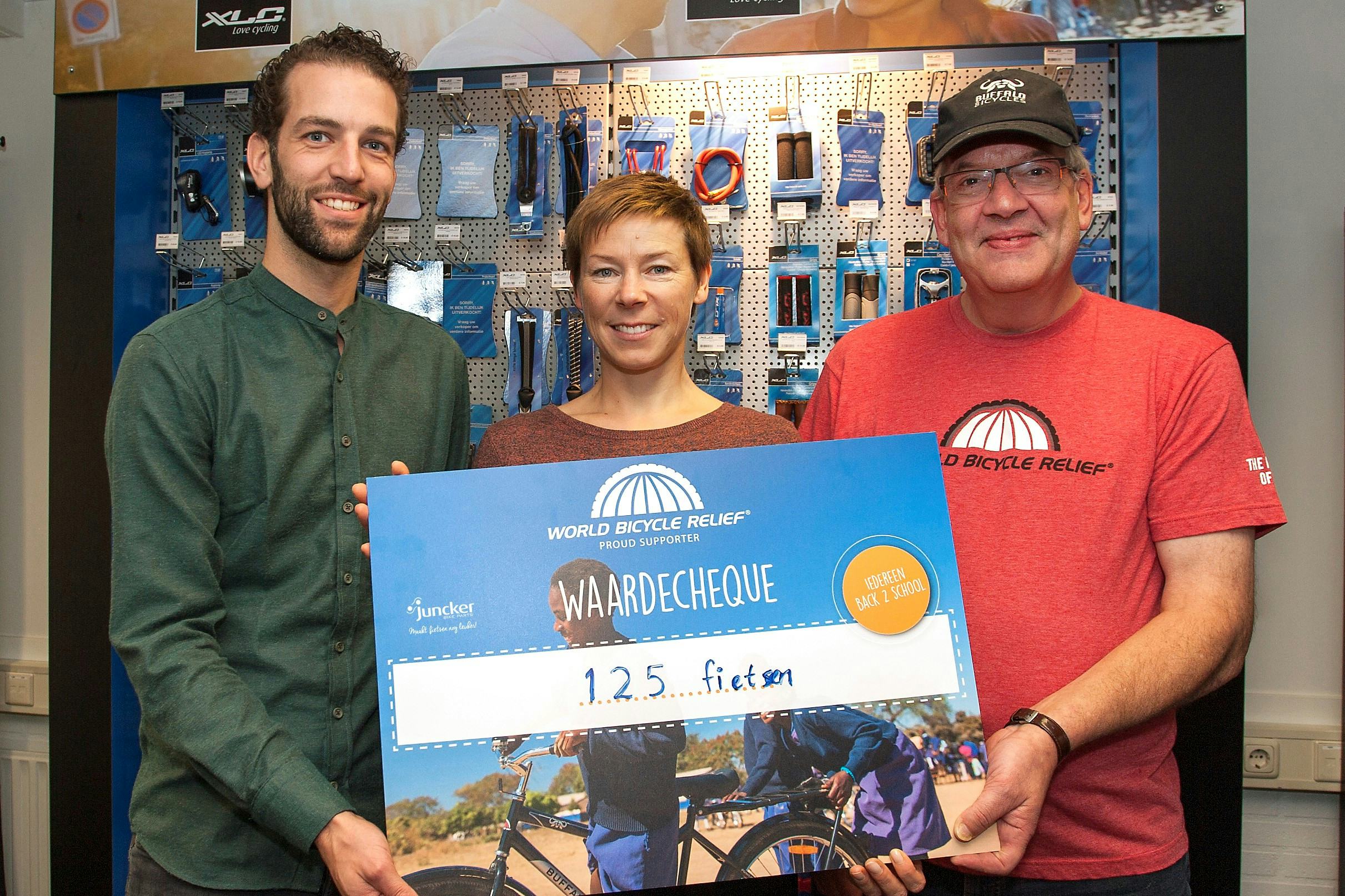 Marketing Manager van Juncker Bike Parts Anton Nijhuis (links) en Jeroen Snijders Blok (COO, rechts) overhandigen de cheque aan Kristina Jasiunaite, Development Director World Bicycle Relief. Foto Juncker Bike Parts