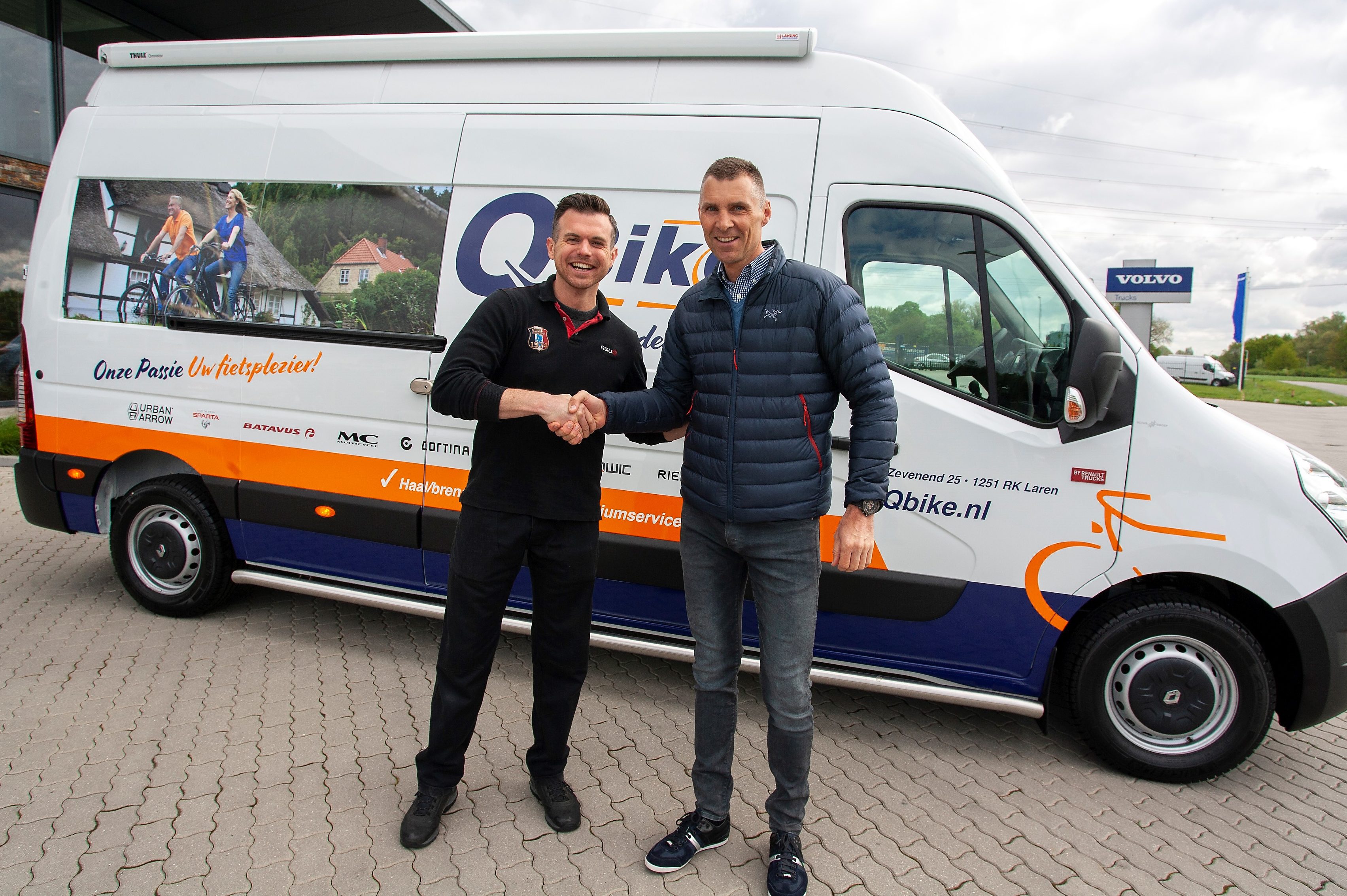 Eigenaar Edwin van den Brink van Qbike krijgt de bus overhandigd uit handen van zijn accountmanager Jan de Leeuw van Juncker. Foto Juncker Bike Parts