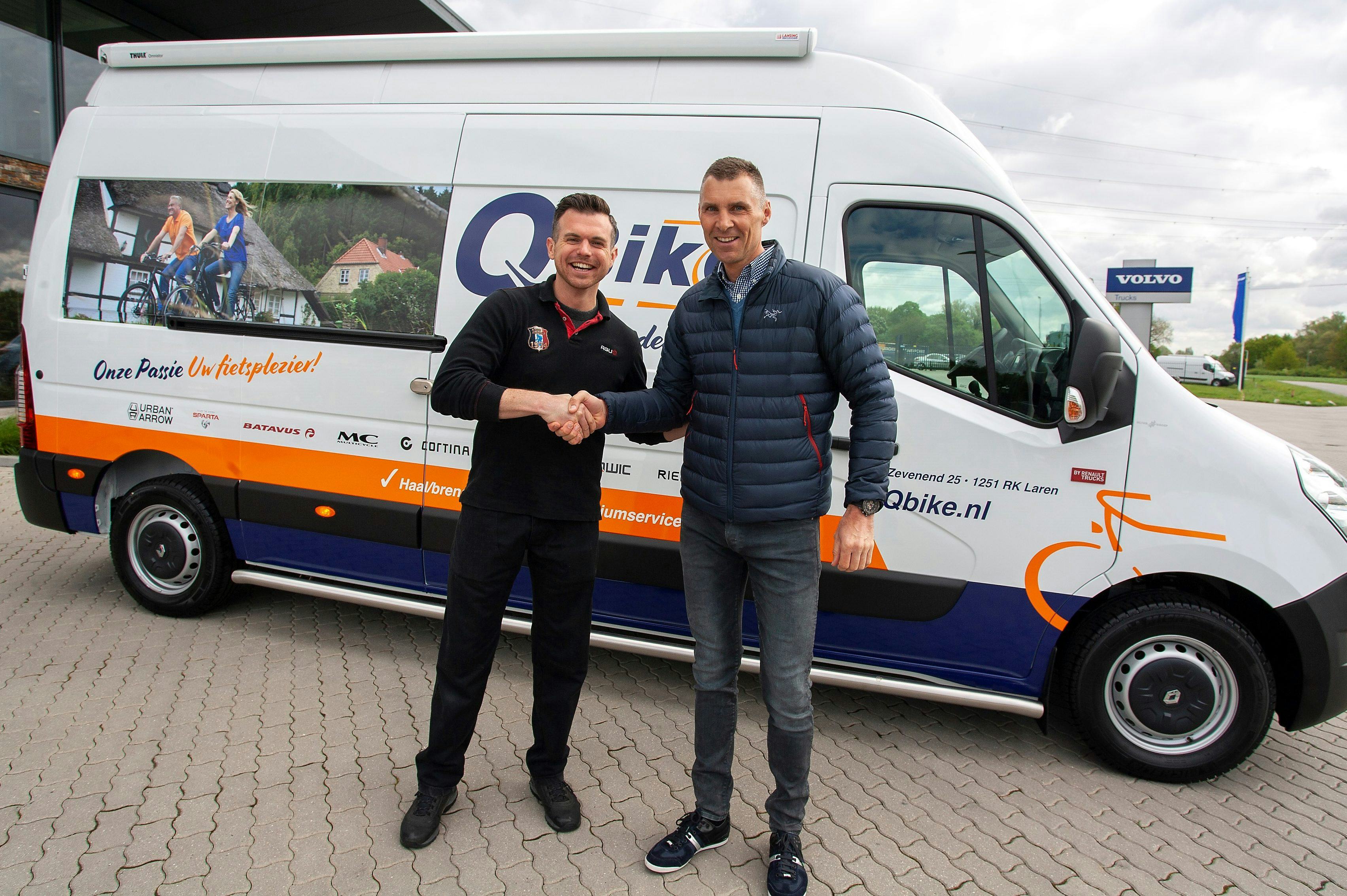 Eigenaar Edwin van den Brink van Qbike krijgt de bus overhandigd uit handen van zijn accountmanager Jan de Leeuw van Juncker. Foto Juncker Bike Parts