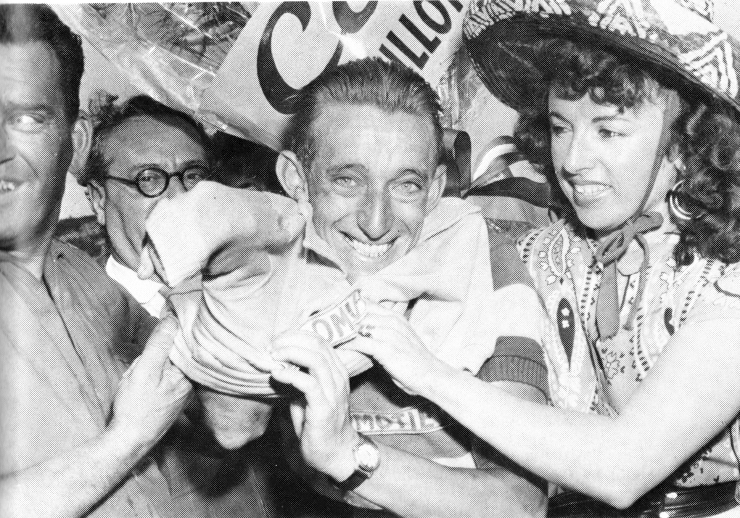 Wout Wagtmans was op zijn Locomotief de eerste Nederlander die de gele trui droeg in de Tour de France. Accordeoniste en Tour-mascotte Yvette Horner helpt hem de trui aantrekken.