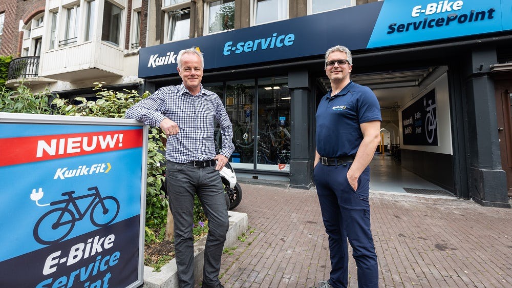 Pieter Bikker (links) en Peter Verhoek staand voor de tot e-service punt omgetoverde KwikFit-Vestiging aan de Overtoom in Amsterdam. Bikker werkt al 21 jaar binnen KwikFit en staat als director e-mobility aan de basis van het nieuwe serviceconcept. Peter Verhoek is concept store manager van de vestiging in Amsterdam. Hij werkt inmiddels tien jaar bij KwikFit. Daarvoor zat hij in de retail. (foto's Diederik van der Laan)