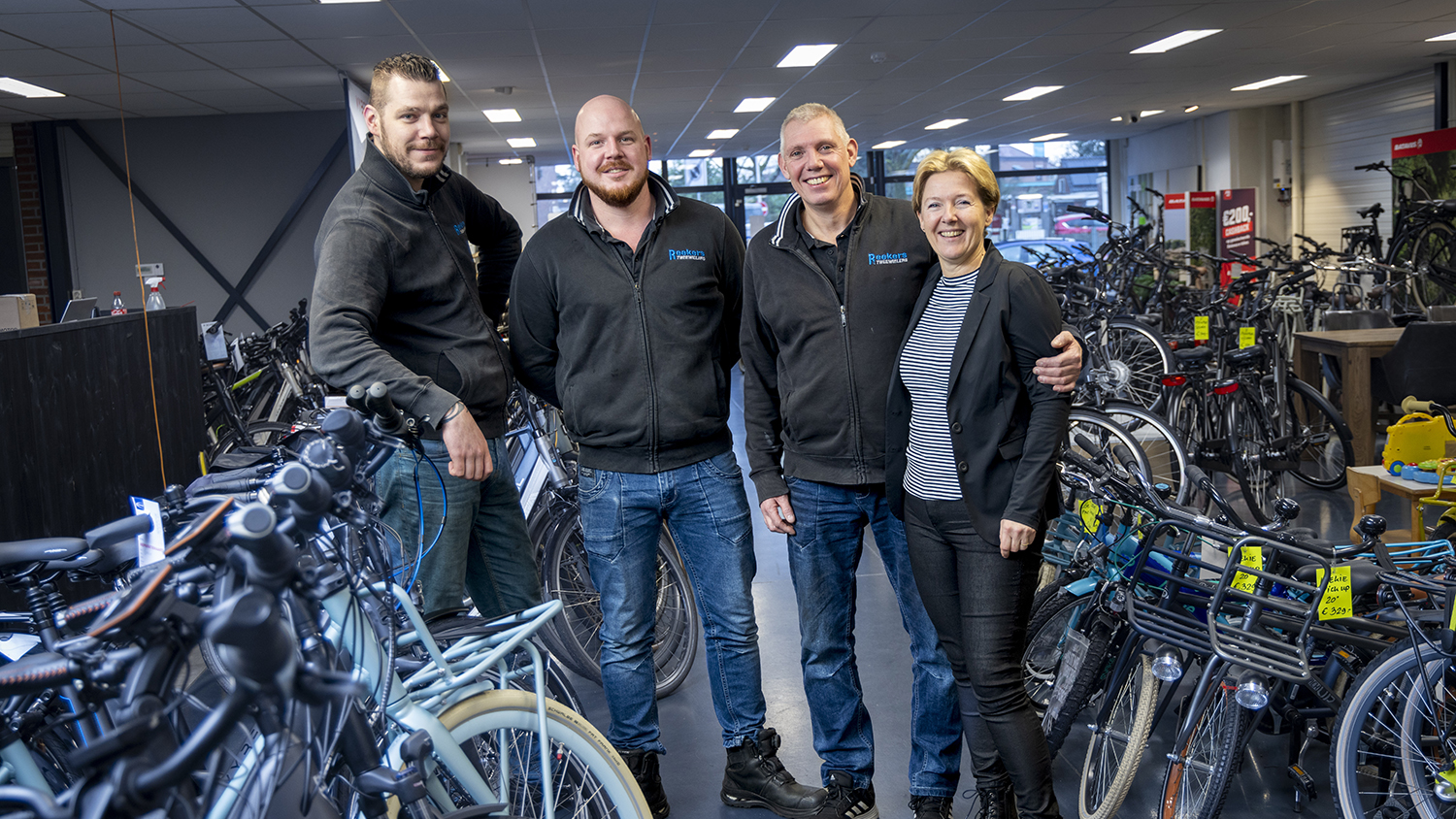Dick Reekers (tweede van rechts) is trots op zijn honderdjarige tweewielerwinkel.