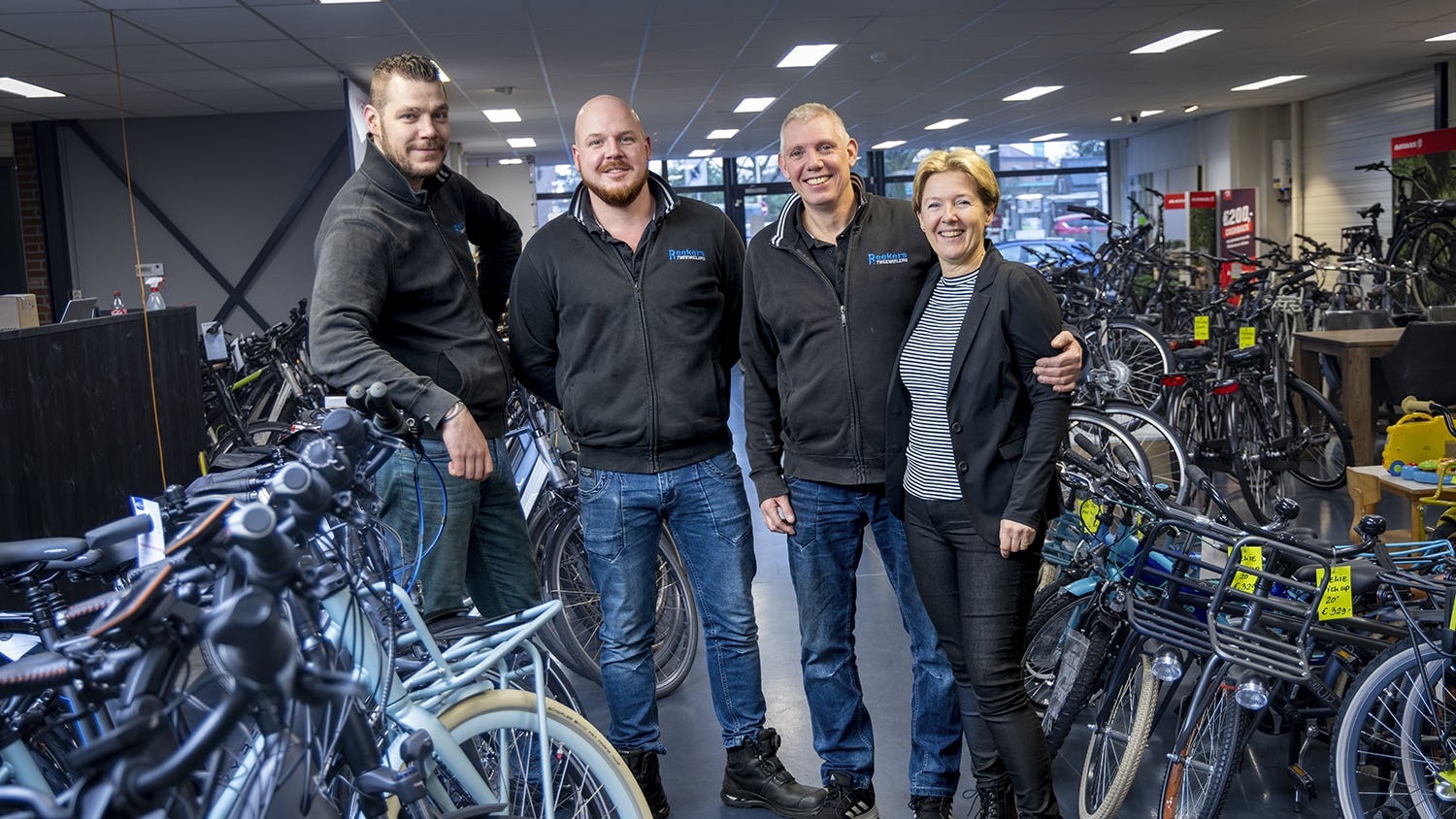 Dick Reekers (tweede van rechts) is trots op zijn honderdjarige tweewielerwinkel.