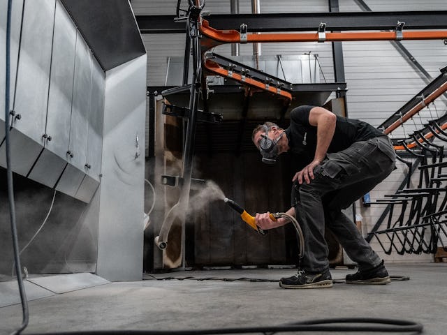 Nils Leeflang poedercoat een fietsframe. Foto: Optima Cycles.