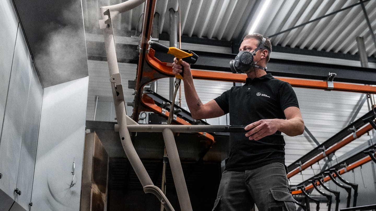 Nils Leeflang poedercoat een fietsframe. Foto: Optima Cycles.