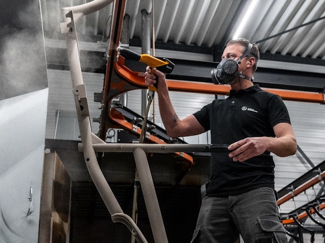 Nils Leeflang poedercoat een fietsframe. Foto: Optima Cycles.